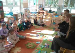 Dzieci słuchają bajek czytanych przez Młodych Radnych Miasta