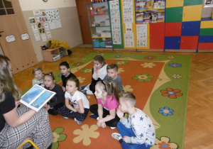 Dzieci z IV grupy słuchają bajki czytanej przez radnych