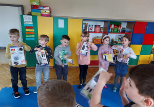 Dzieci wyszukują w gazetkach przedmiotów z głoską sz w nazwie