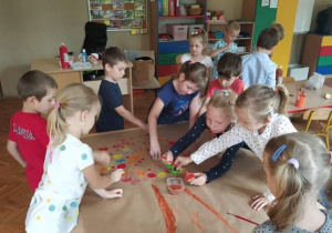 dzieci z grupy 2 tworzą wspólną pracę plastyczną z użyciem farb