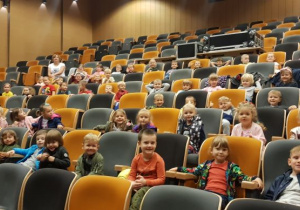 Dzieci siedzą na swoich miejscach w kinie