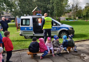 Dzieci czekają aby obejrzeć wóz policyjny