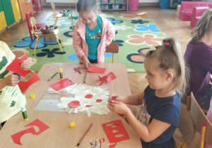 Dzieci wycinają jabłka z czerwonego papieru
