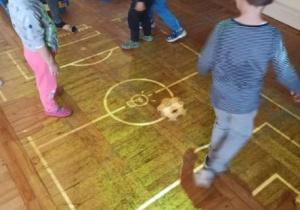 Dzieci grają w piłkę nożna na dywanie interaktywnym