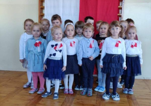 Grupa IV na tle flagi i godła Polski