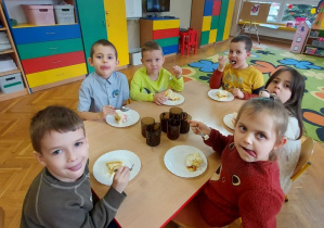 Dzieci z grupy II oblizują bużki podczas jedzenia tortu