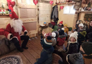 Dzieci słuchają opowieści w chacie Mikołaja