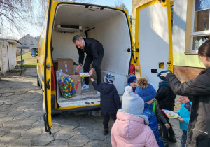 Dzieci pomagają ładować dary do auta