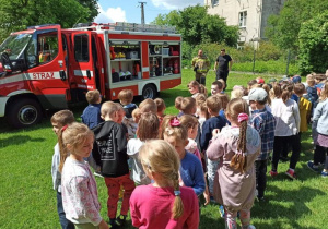 Dzieci obserwują wyposażenie wozu strażackiego