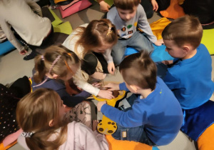 Dzieci z grupy 3 układają żyrafę z klocków